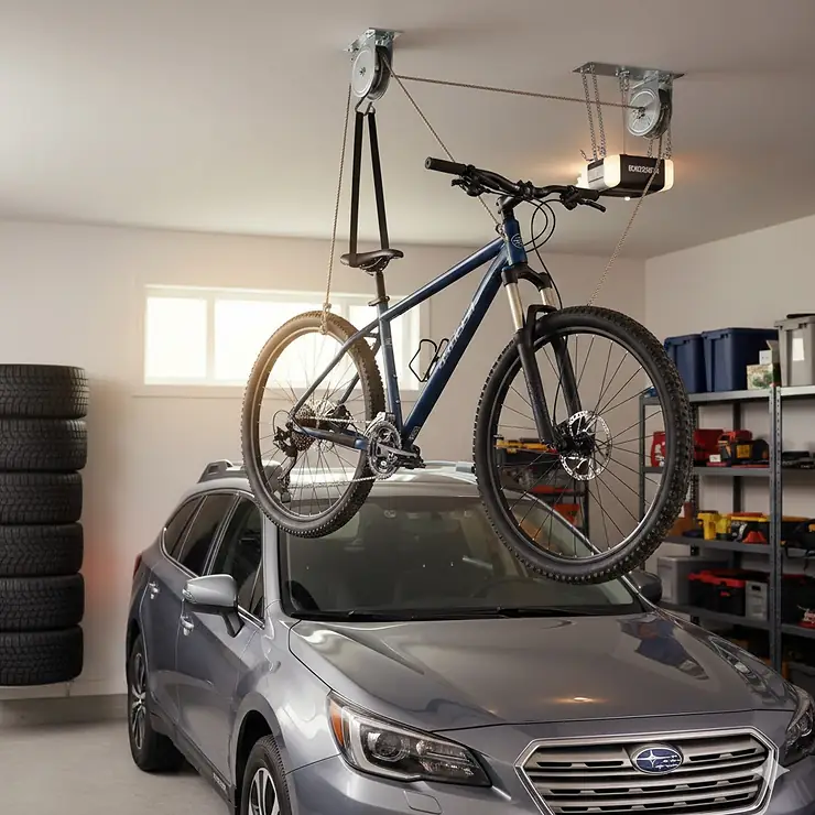 A mountain bike suspended by a ceiling bike storage pulley system in a clean Canadian garage, saving floor space for winter tire storage.