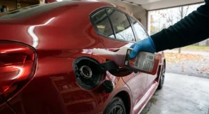 Adding fuel stabilizer to a full gas tank to prevent moisture buildup during a long Canadian winter.