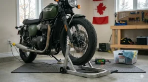 A motorcycle elevated off a cold concrete garage floor using a front paddock stand wheel chock, demonstrating how specialized motorcycle winter storage products prevent tire flat-spotting over the winter.