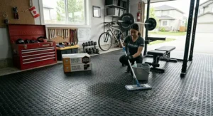 A person cleaning heavy duty rubber garage tiles with a damp cloth or mop.