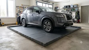 A large SUV parked on a heavy-duty containment mat in a clean garage.