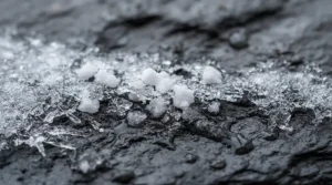 Close-up of ice melt for driveways dissolving frost quickly on a frozen surface.